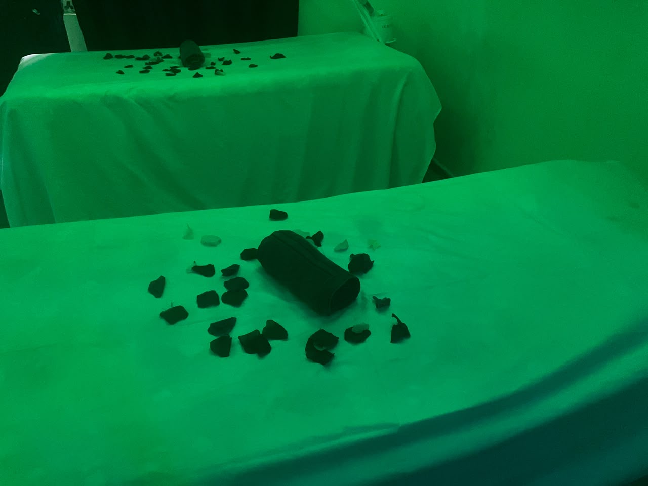 A treatment bed made up with rose petals, lit in green